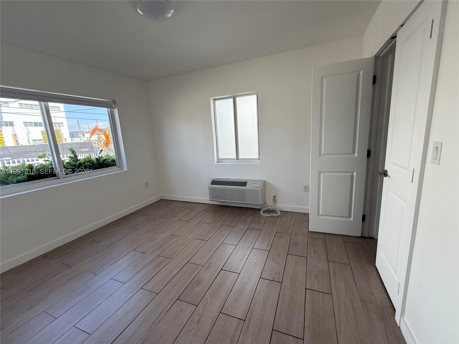 625 77th Street, Unit 2 Miami Beach, FL 33141 - Photo 16 of 17 a view of empty room with wooden floor and fan