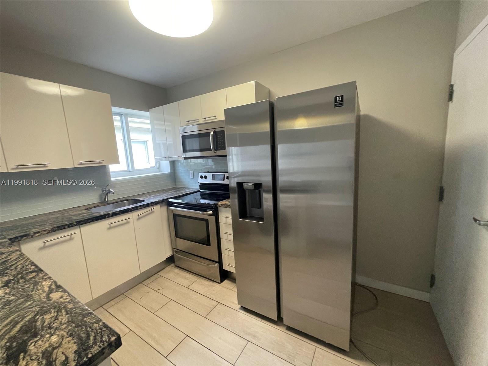 625 77th Street, Unit 2 Miami Beach, FL 33141 - Photo 6 of 17 a kitchen with a refrigerator and a sink