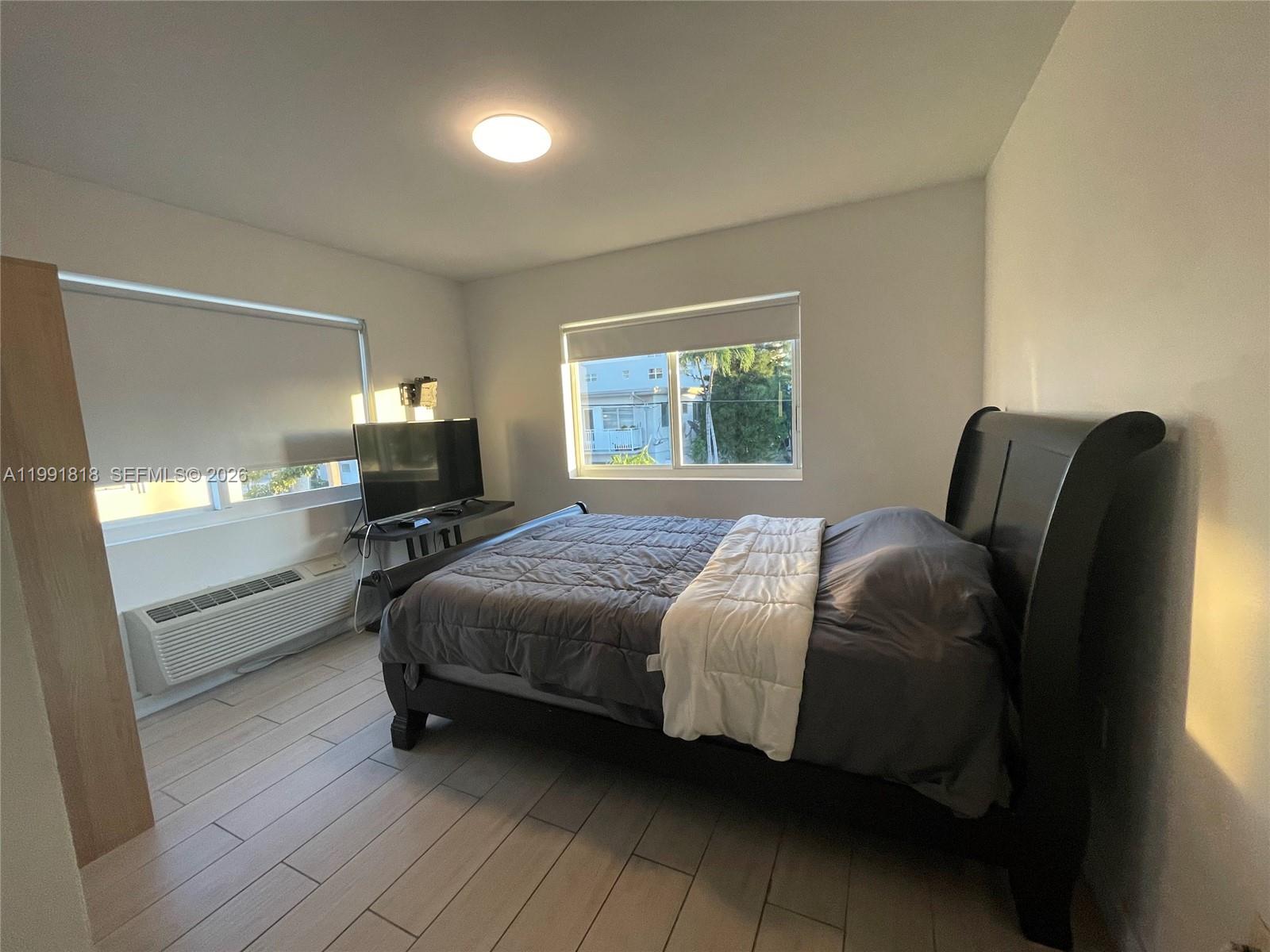 625 77th Street, Unit 2 Miami Beach, FL 33141 - Photo 9 of 17 a bedroom with a bed and wooden floor