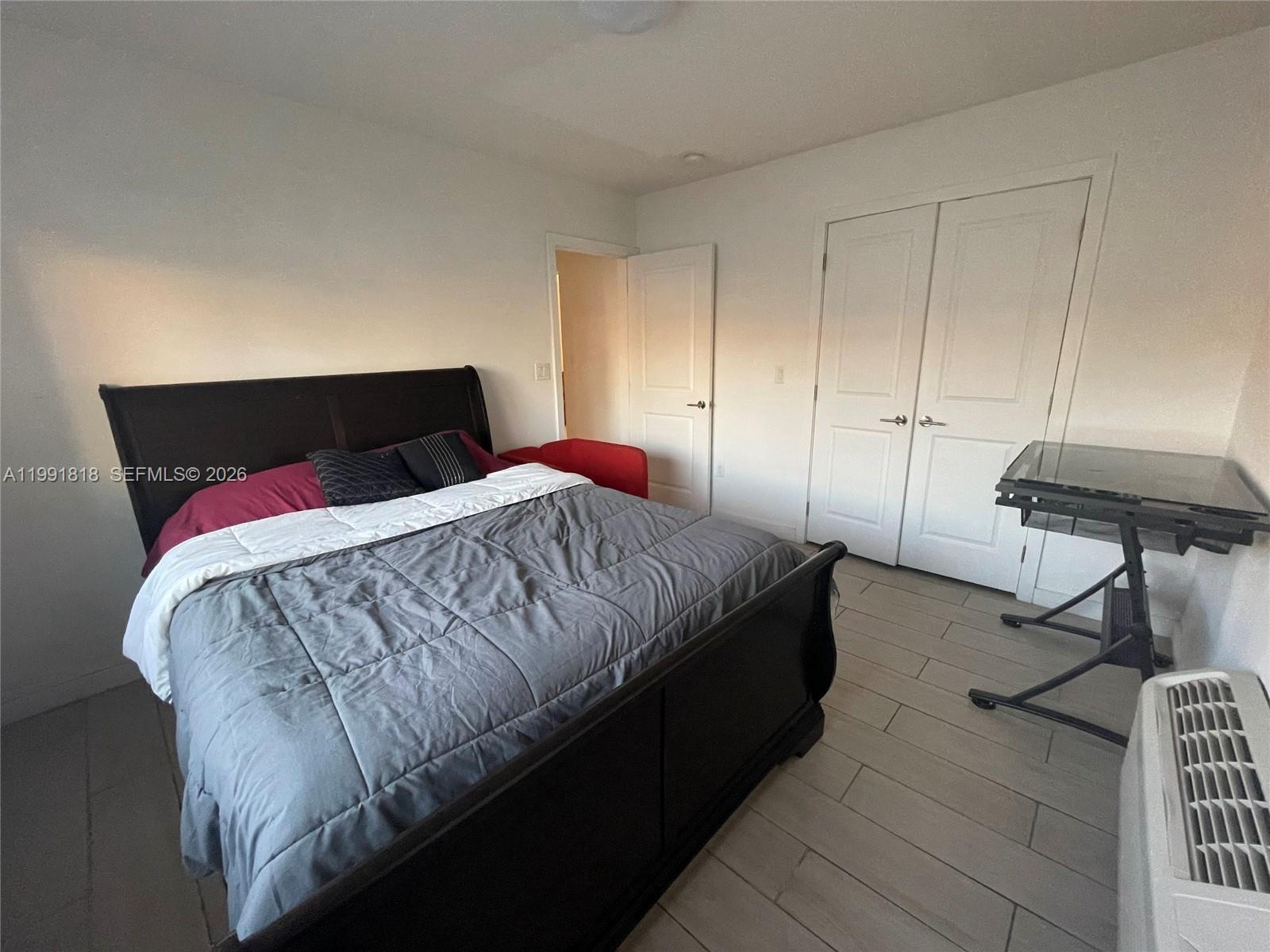 625 77th Street, Unit 2 Miami Beach, FL 33141 - Photo 10 of 17 a bedroom with a bed and a potted plant