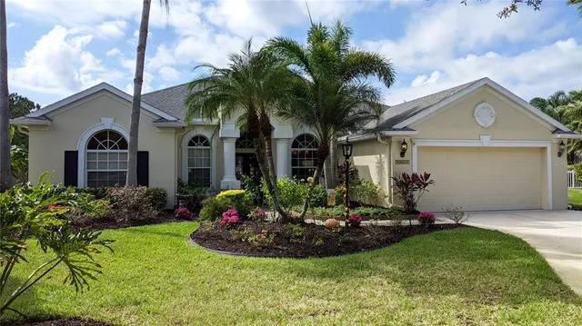 a front view of a house with a garden and plants