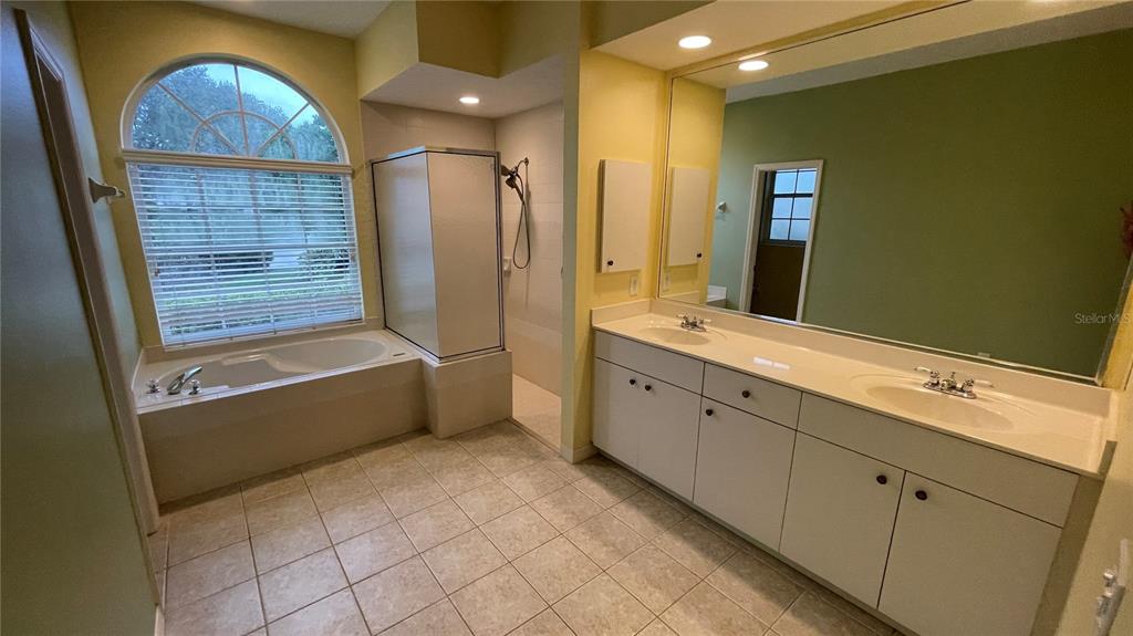 10812 Bullrush Terrace Lakewood Ranch, FL 34202 - Photo 19 of 44 a spacious bathroom with a double vanity sink a mirror and a bathtub