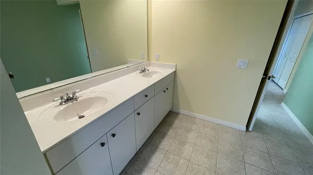 a bathroom with a double vanity sink and a mirror