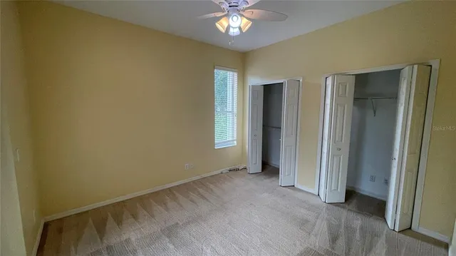 a view of an empty room with a chandelier fan