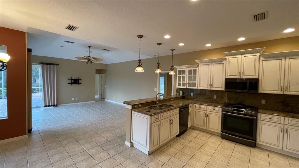 10812 Bullrush Terrace Lakewood Ranch, FL 34202 - Photo 6 of 44 a kitchen with stainless steel appliances granite countertop a stove and a sink