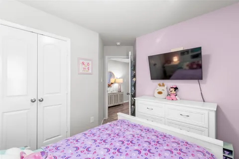 a bedroom with a bed and a flat screen tv in it