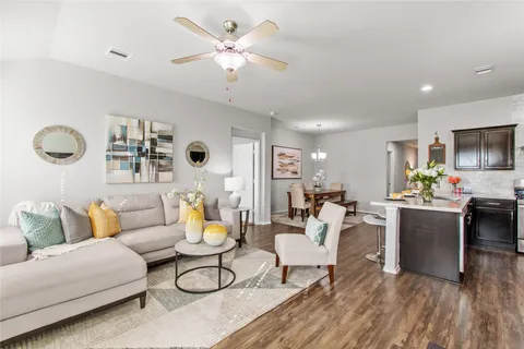 a living room with furniture and kitchen view