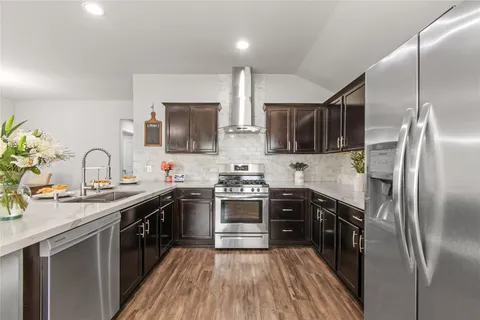 a kitchen with stainless steel appliances granite countertop a sink stove and refrigerator