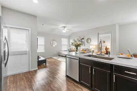 a kitchen with a sink cabinets and wooden floor