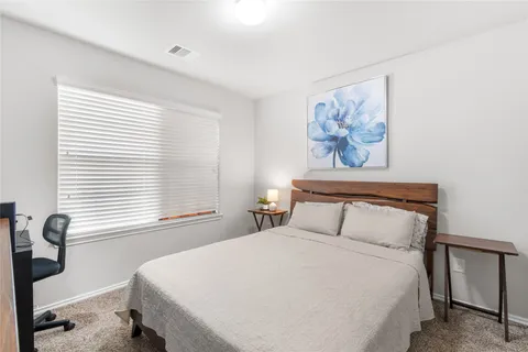 a bedroom with a large bed and a window