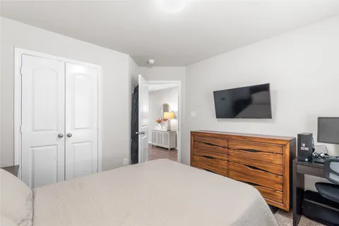 a bedroom with a bed and a flat screen tv