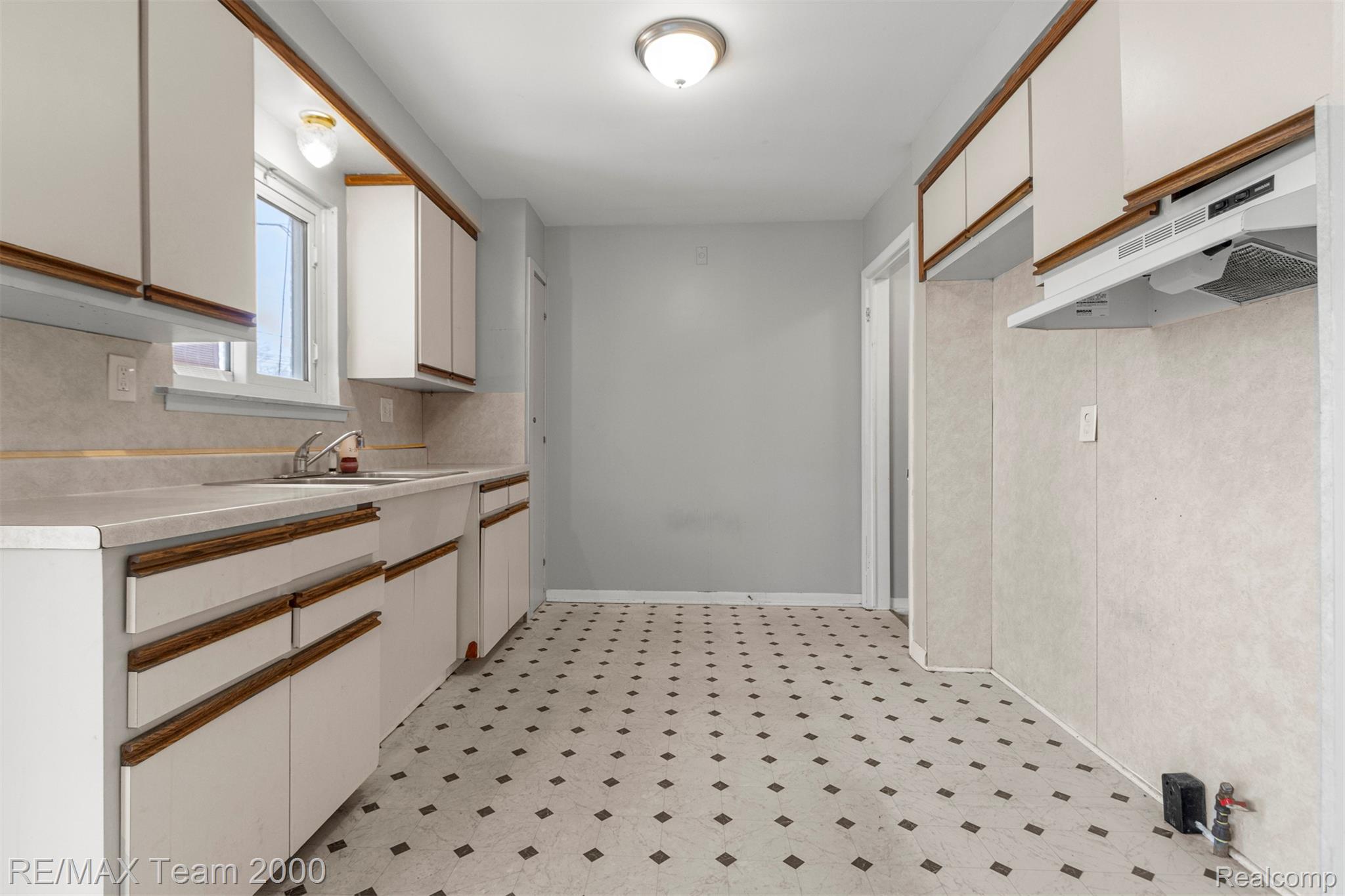 19431 Stephens Road Eastpointe, MI 48021 - Photo 11 of 46 Kitchen with light flooring, dual tone cabinets, and light countertops