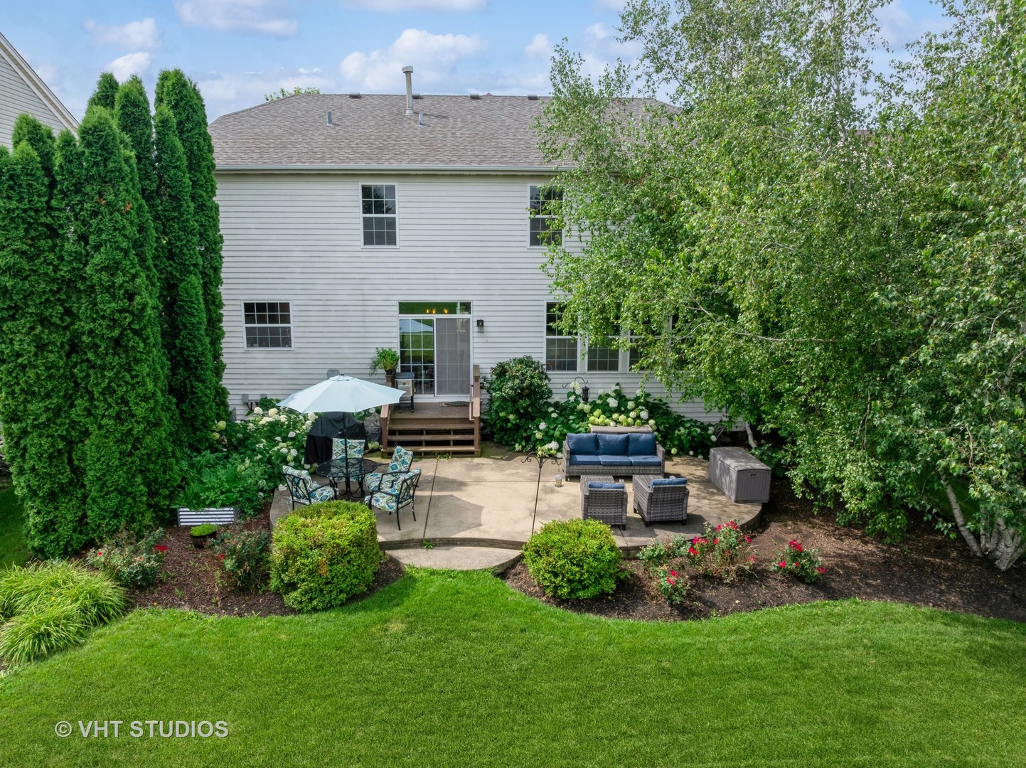 390 Sterling Circle Cary, IL 60013 - Photo 40 of 55 a front view of a house with a garden and sitting area