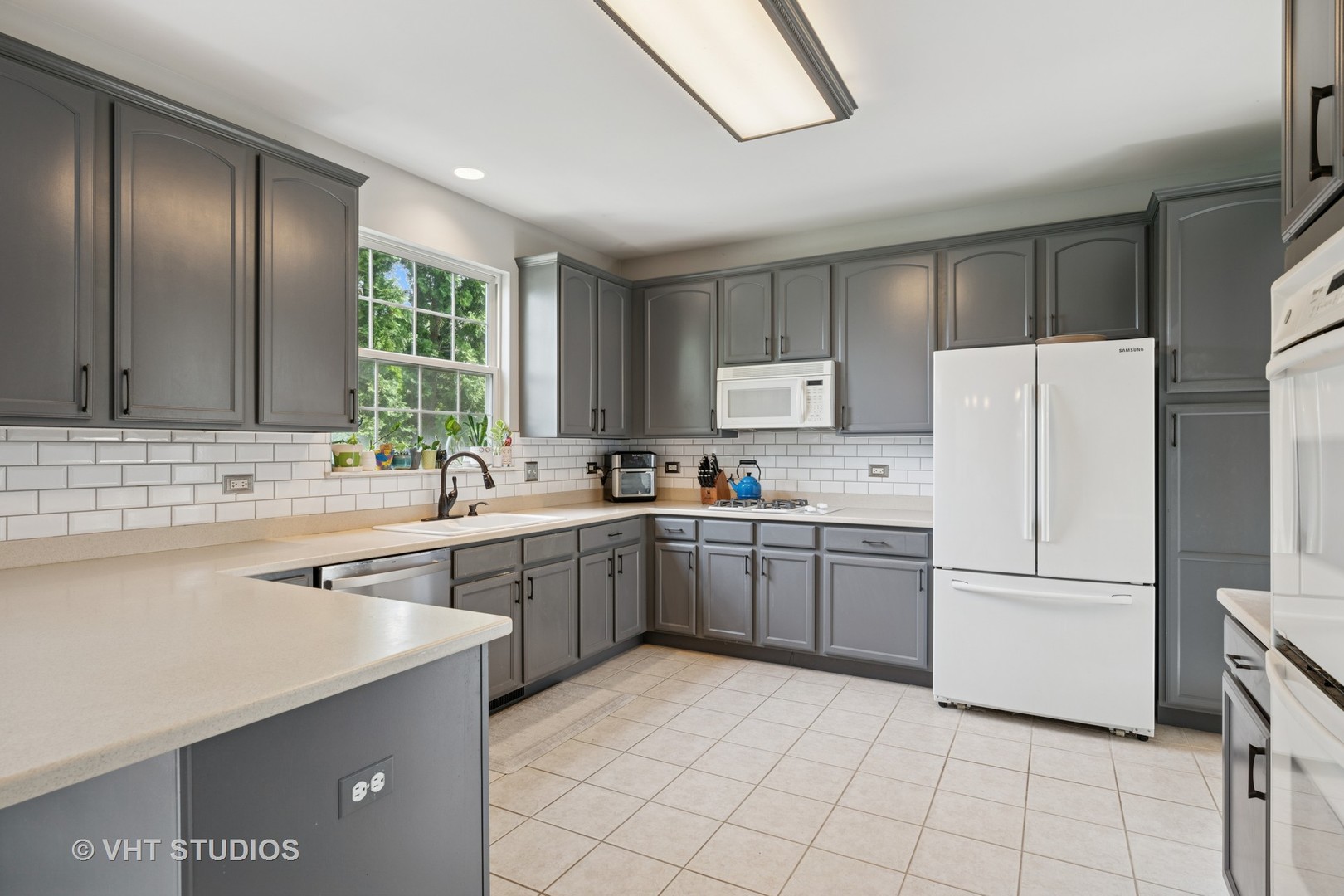 390 Sterling Circle Cary, IL 60013 - Photo 8 of 55 a kitchen with a refrigerator sink and cabinets