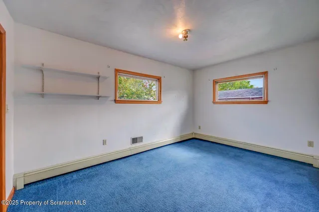 a view of a room with wooden floor and windows