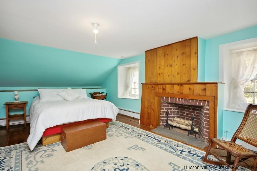 138 Pine Bush Road Stone Ridge, NY 12484 - Photo 16 of 34 a bedroom with a bed and a fireplace