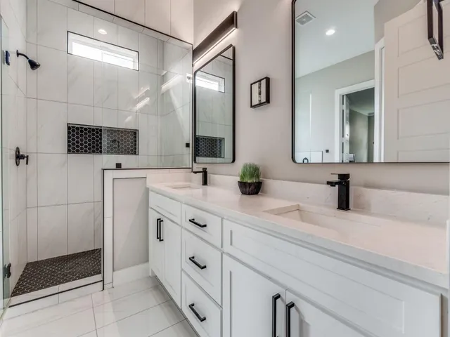 a bathroom with a double vanity sink mirror and shower