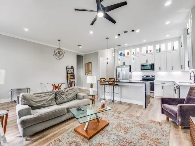 a living room with furniture kitchen view and a chandelier