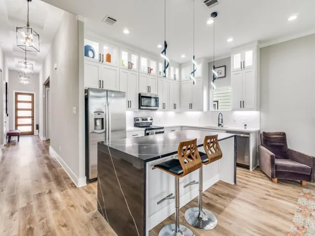 a kitchen with stainless steel appliances kitchen island granite countertop a refrigerator and a stove top oven