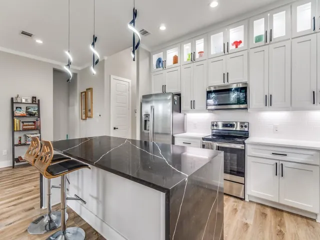 a kitchen with kitchen island a sink stove and refrigerator