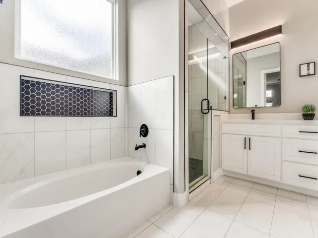 a bathroom with a bathtub a sink a vanity and a shower