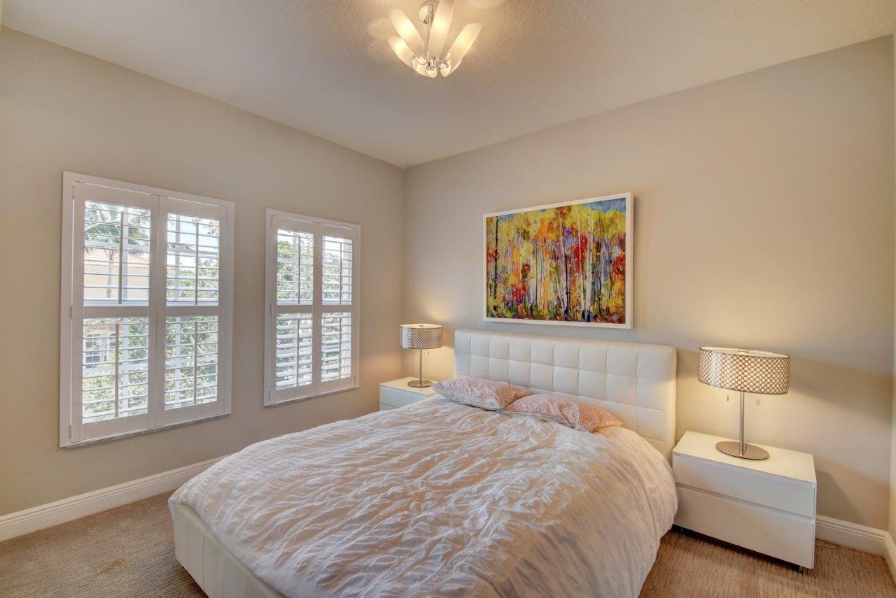 5610 Northeast Trieste Terrace Boca Raton, FL 33487 - Photo 33 of 44 a bedroom with a large bed and a large window