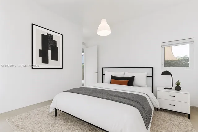 a bedroom with a large bed and a lamp