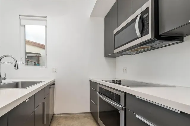 a kitchen with stainless steel appliances cabinets and a window