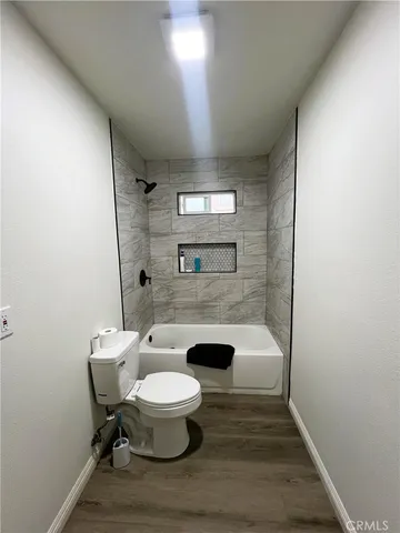 a bathroom with a sink a toilet a mirror and shower