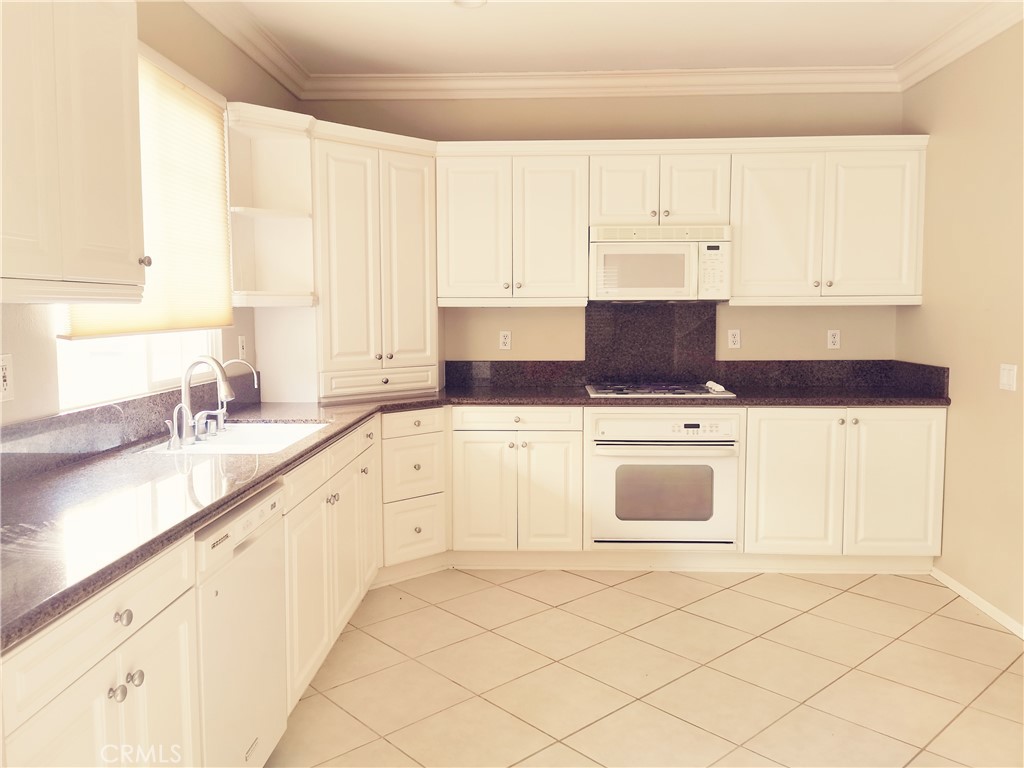 41 Modesto Irvine, CA 92602 - Photo 4 of 20 a kitchen with granite countertop white cabinets and white appliances