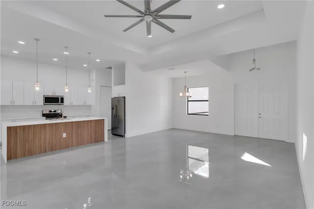 a kitchen with kitchen island a counter top space appliances and a sink