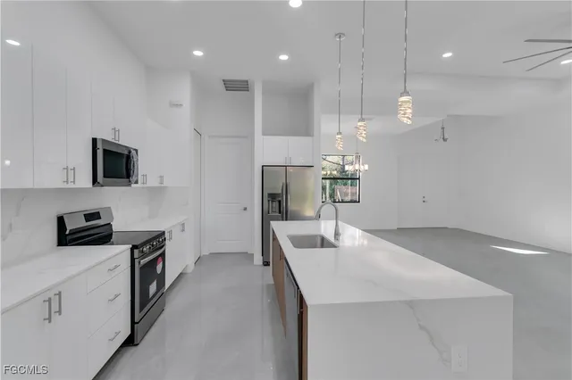 a kitchen with kitchen island a sink stainless steel appliances and counter space