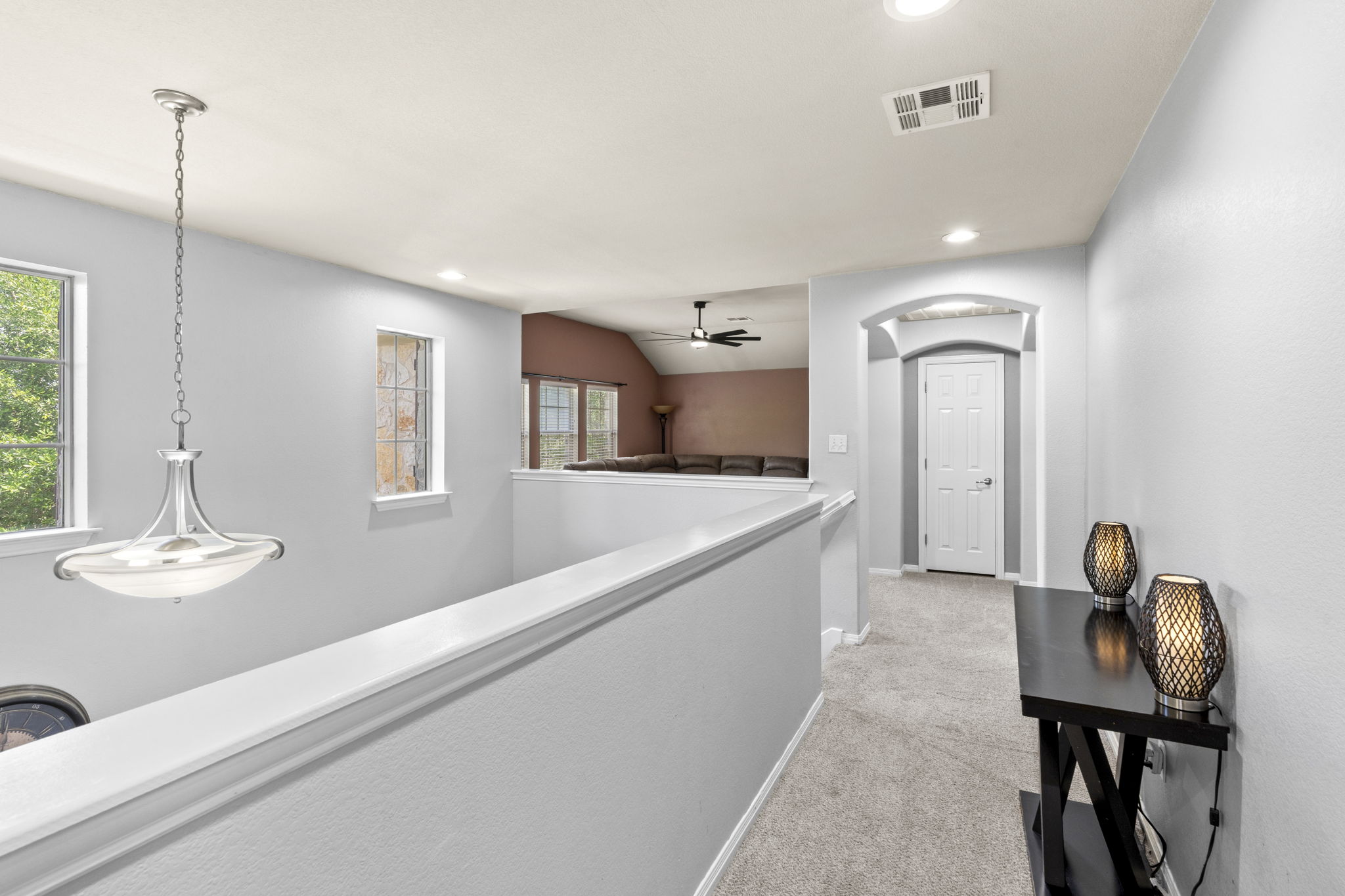 227 Sandstone Trail Buda, TX 78610 - Photo 29 of 33 Upper-level hallway with light gray walls, recessed lighting, and a contemporary chandelier