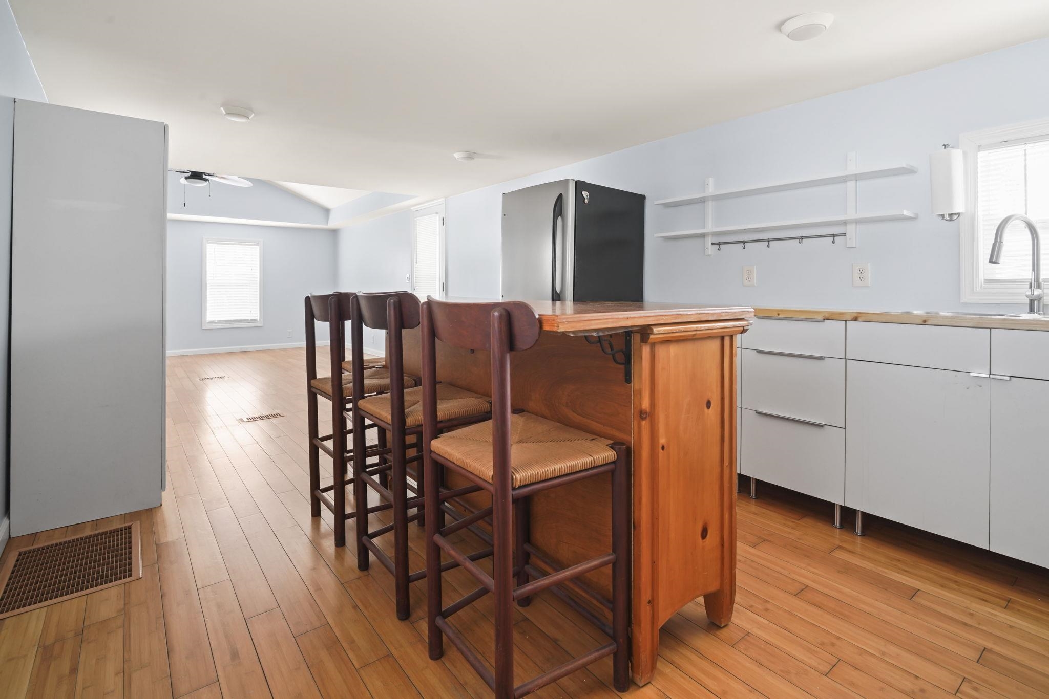 45 Shamrock Circle Murrells Inlet, SC 29576 - Photo 23 of 32 Kitchen with a kitchen bar, white cabinets, brown cabinetry, and light wood-type flooring
