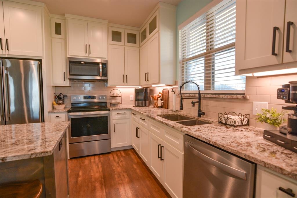 601 Mathew Street Grandview, TX 76050 - Photo 10 of 40 a kitchen with stainless steel appliances granite countertop a sink stove microwave refrigerator and cabinets