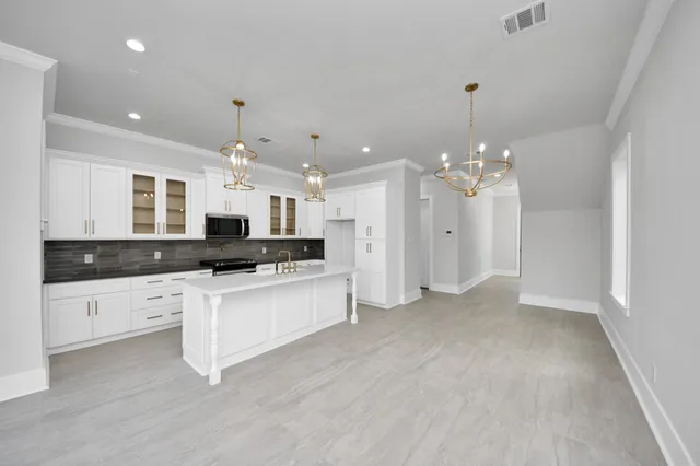 a view of a big room with wooden floor and windows