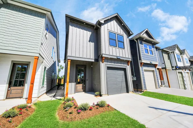 a front view of a house with a yard and green space