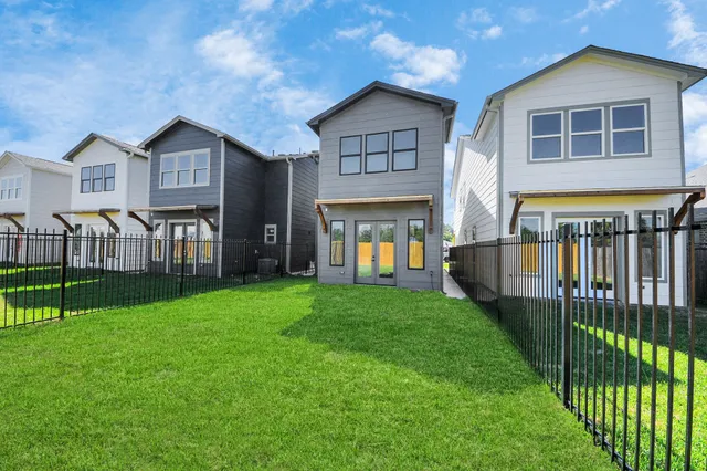a view of house with a big yard and large trees