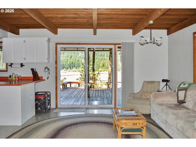 a living room with furniture a flat screen tv and kitchen view
