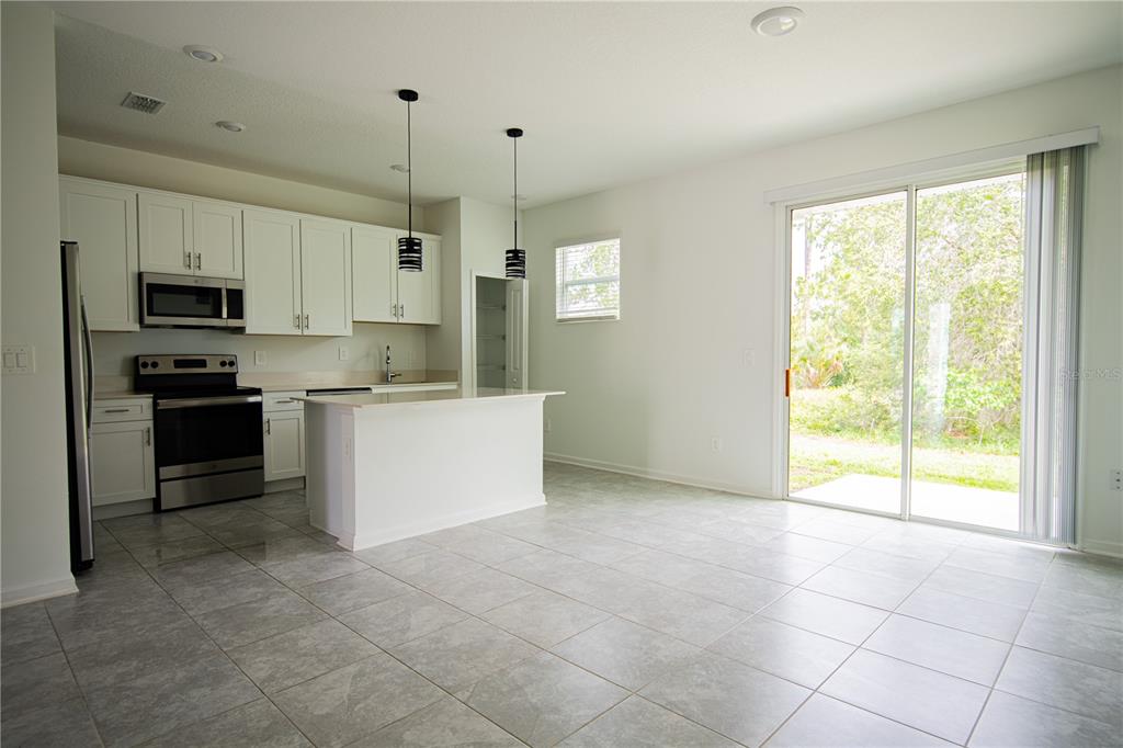 2340 Brook Marsh Loop Kissimmee, FL 34747 - Photo 26 of 53 a kitchen with kitchen island a sink a counter top space cabinets and stainless steel appliances