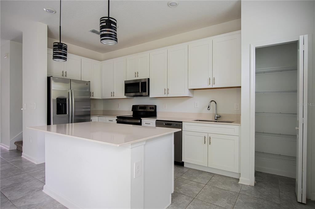 2340 Brook Marsh Loop Kissimmee, FL 34747 - Photo 28 of 53 a kitchen with a sink a stove and refrigerator