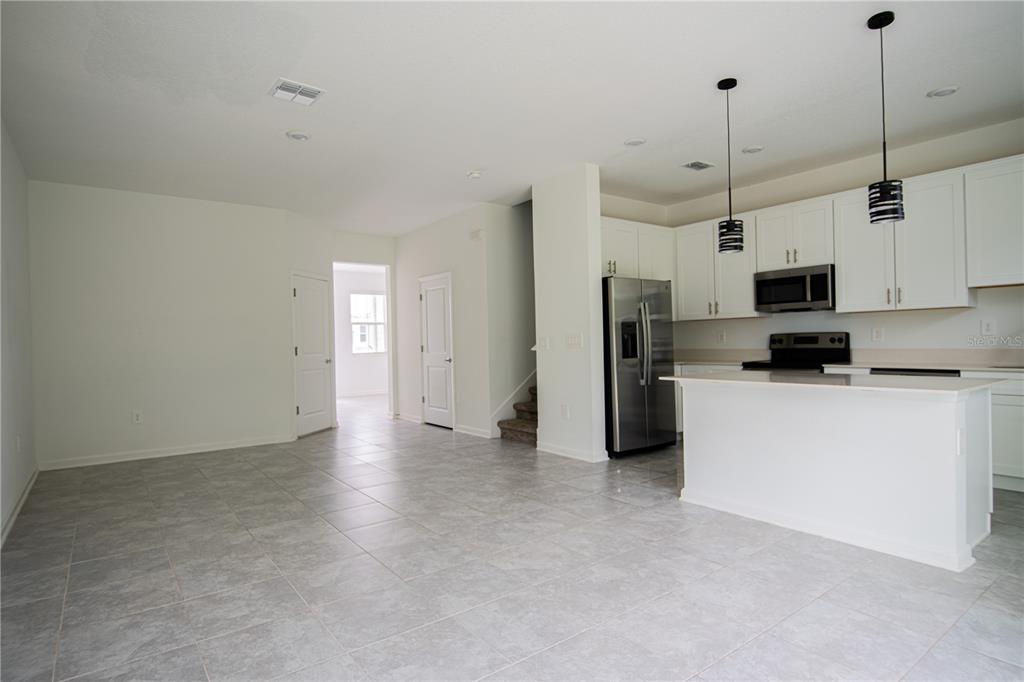 2340 Brook Marsh Loop Kissimmee, FL 34747 - Photo 31 of 53 a view of a kitchen with refrigerator and a fireplace