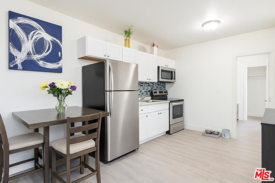356 West 90th Street, Unit 1/2 Los Angeles, CA 90003 - Photo 1 of 2 a kitchen with a refrigerator and a table
