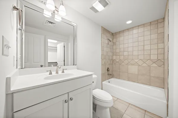 a bathroom with a sink a toilet a mirror a bathtub and shower