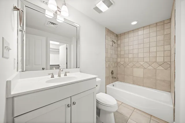 a bathroom with a sink a toilet a mirror a bathtub and shower