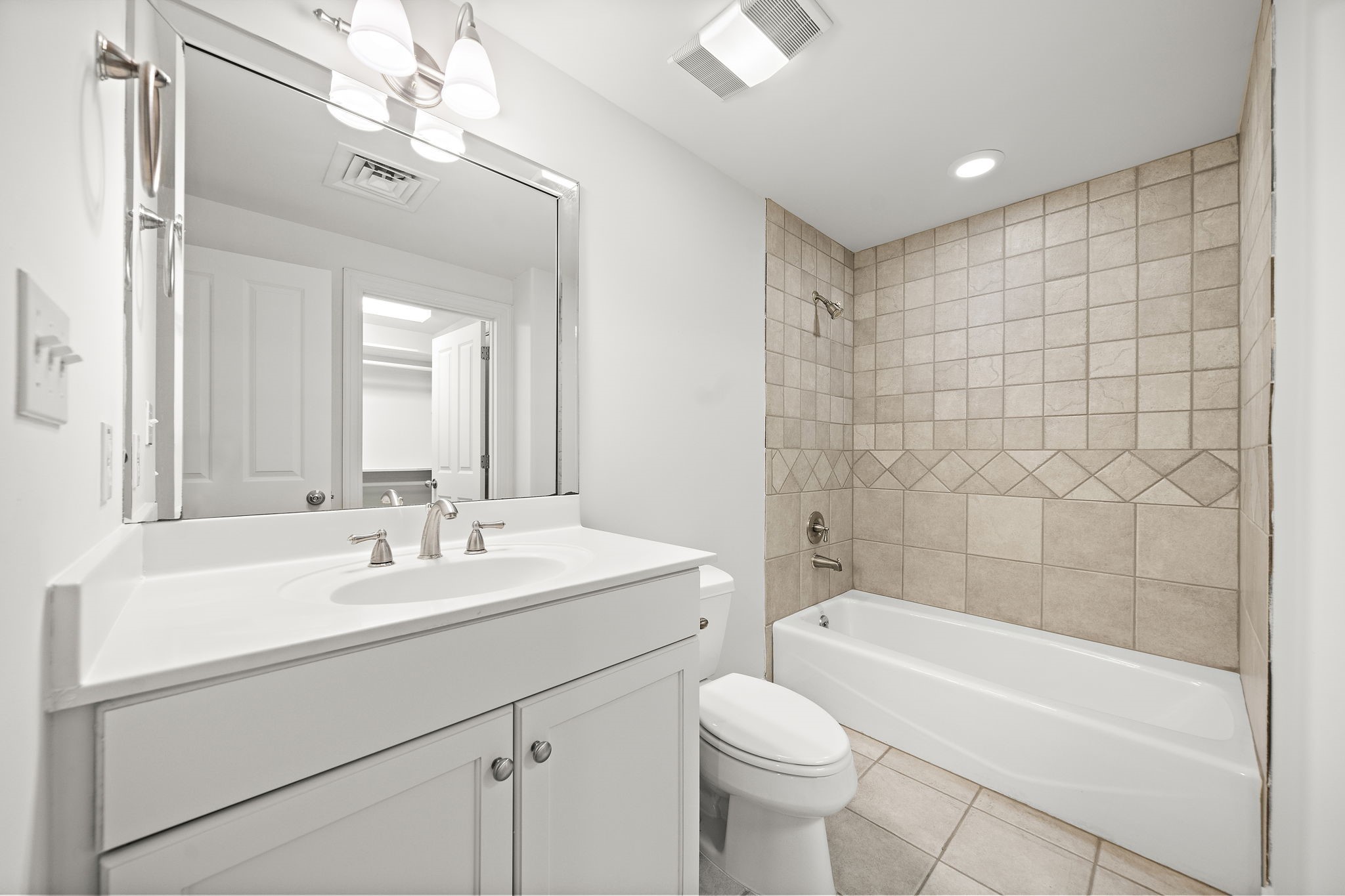 914 Main Street, Unit 1105 Houston, TX 77002 - Photo 10 of 22 a bathroom with a sink a toilet a mirror a bathtub and shower