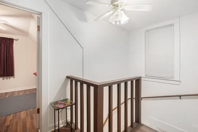 a view of staircase with white walls and fan