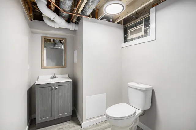 a bathroom with a toilet sink and mirror