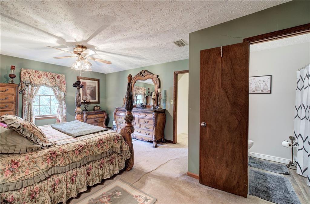 3637 Nebo Road Hiram, GA 30141 - Photo 35 of 63 a bedroom with a large bed a chandelier and dresser