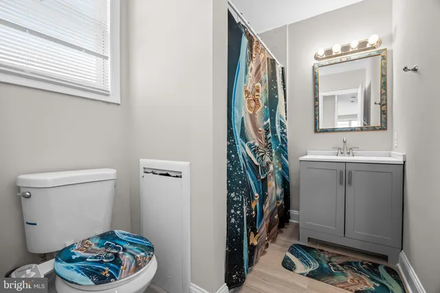 a bathroom with a toilet a sink and a mirror